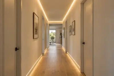 Continuous warm cove light washing along a smooth ceiling, the kind of raking light that shows every flaw in a finish